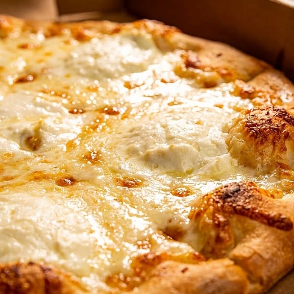 Close-up of a hot, cheesy white pizza with a golden crust in a cardboard box.